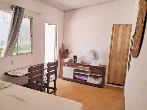 een kamer met een bed, een tafel en een raam bij Casinha Guiné in Morro de São Paulo