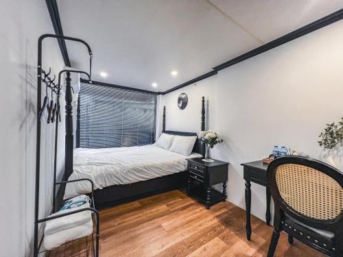 a bedroom with a bed and a desk with a chair at 2 Indochine Design Apartment - Hanoi Old Quarter in Hanoi