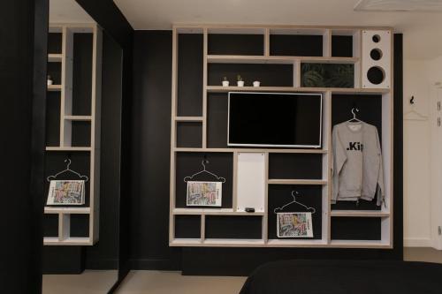 a room with a television and a shelf with pictures on it at Kip Hotel in London