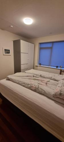 a bedroom with a large bed with a large window at Iceland-Aurora in Laugaras