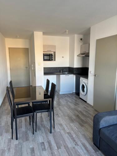 un salon avec une table et des chaises et une cuisine dans l'établissement Appartement T2 Parking, à Marseille