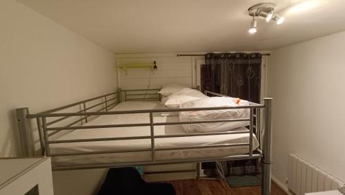a bedroom with a bunk bed with white sheets at Studio 4 personnes au pied des piste plateau de Bonascre - Ax 3 domaines Eté Hiver in Ax-les-Thermes