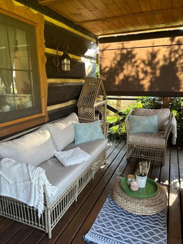 a porch with a couch and chairs on a deck at Chata Sanna in Lesko