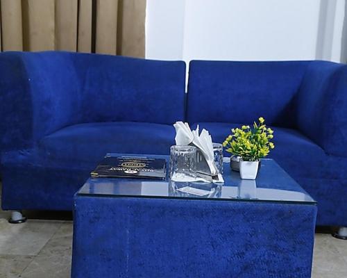 a blue couch and a table with a blue couch and flowers at Hotel Royal castle in Zirakpur