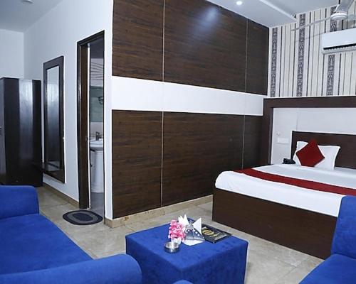a bedroom with a bed and a blue couch at Hotel Royal castle in Zirakpur