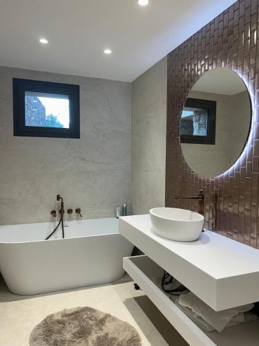 a bathroom with a tub and a sink and a mirror at Casa Raphael in Ajaccio