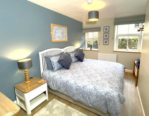 a bedroom with a bed with blue walls and a lamp at Weavers Rest - New Boutique Retreat in Central Skipton with Parking in Skipton