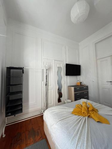 a bedroom with a bed with a yellow bow on it at Garden Campo de Ourique Guest House - Hostel in Lisbon