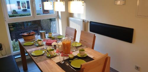 a dining room table with green plates and drinks on it at Ferienwohnung "SCHÖNBUCH" , Pension Wauri in Waldenbuch