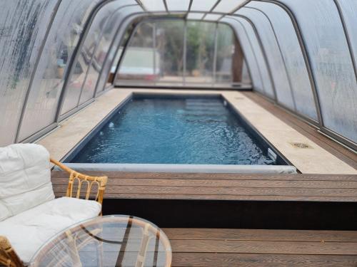 a hot tub in a room with a chair at Naomi's in Rosh Pinna