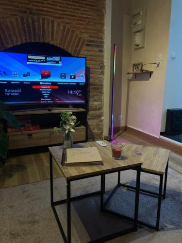 un salon avec une table basse et une télévision dans l'établissement La Jungle Room, à Troyes