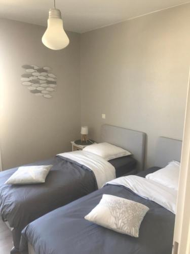 - une chambre avec deux lits et une lumière dans l'établissement Les Villas d 'Opale, à Berck-sur-Mer
