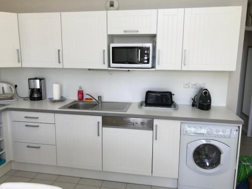 une cuisine blanche avec un évier et un micro-ondes dans l'établissement Les Villas d 'Opale, à Berck-sur-Mer
