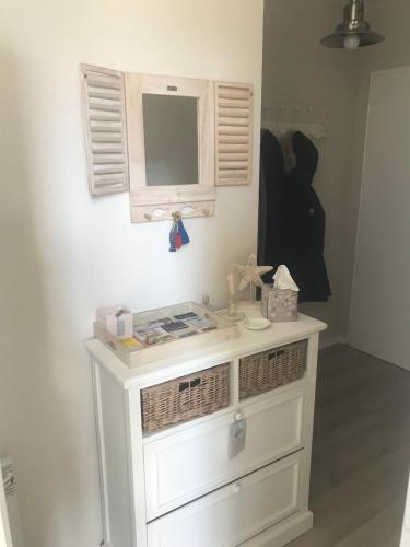 La salle de bains est pourvue d'une commode blanche avec un miroir. dans l'établissement Les Villas d 'Opale, à Berck-sur-Mer