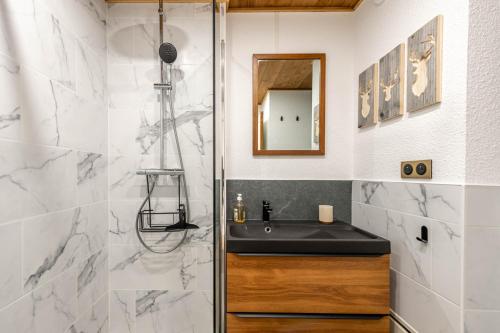 une salle de bain avec un lavabo et une douche dans l'établissement SmartStay Panoramique - Meribel, à Méribel