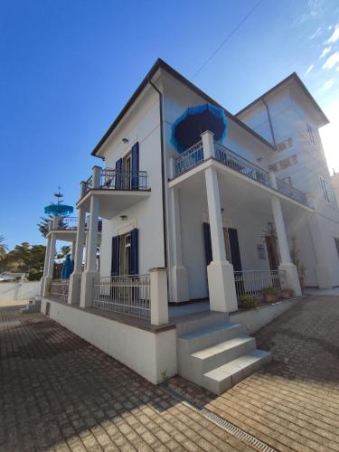 a white house with stairs in front of it at Marina Azzurra VistaMare - HiTuscany in Marina di Campo