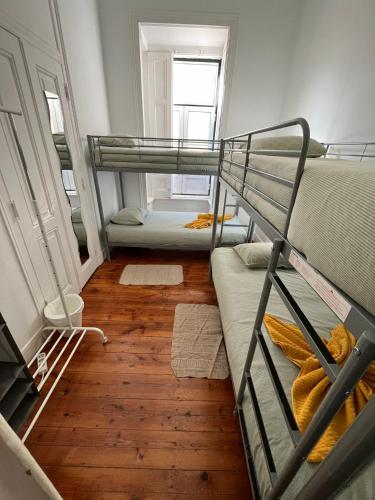 a room with two bunk beds and a wooden floor at Garden Campo de Ourique Guest House - Hostel in Lisbon