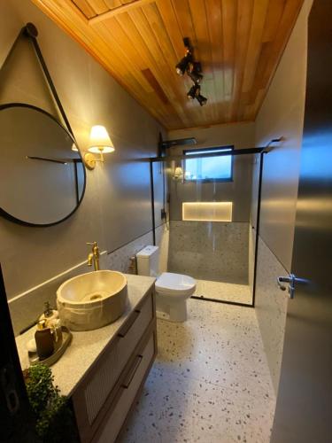 a bathroom with a sink and a toilet and a mirror at Cabana Santo Rancho Treze Tílias in Treze Tílias