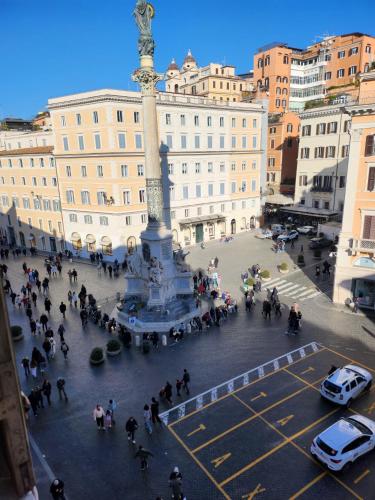 a crowd of people walking around a statue in a city at Piazza di Spagna 51 Luxury guest house in Rome