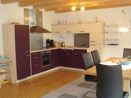 a kitchen with wooden cabinets and a table with chairs at Ferienhaus Brütting in Pottenstein