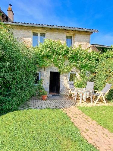 Maison en pierre avec 2 chaises et une table dans l'établissement Cottage l'Atelier, aire de loisirs avec piscine, à Marigny
