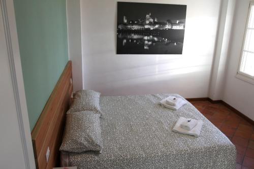 a bedroom with a bed with two towels on it at Ostello Dei Concari in Governolo