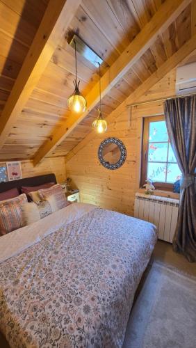 a bedroom with a large bed in a wooden house at Retreat House Kolašin in Kolašin