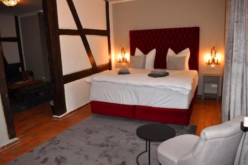 a bedroom with a large bed with a red headboard at Saniertes Gutshaus mit Komfort und privater Sauna in Neu Gaarz