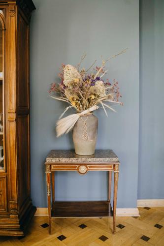a vase of flowers on a table next to a wall at Saniertes Gutshaus mit Komfort und privater Sauna in Neu Gaarz