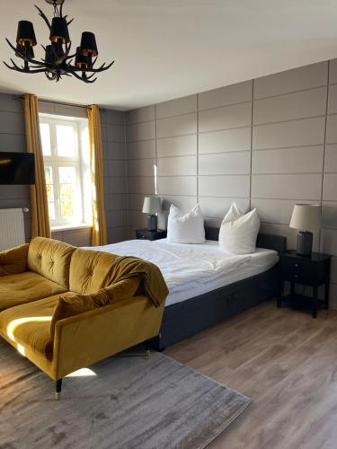 a bedroom with a bed and a couch at Saniertes Gutshaus mit Komfort und privater Sauna in Neu Gaarz