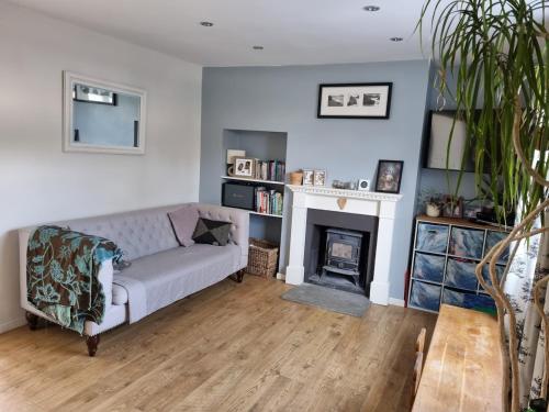 a living room with a couch and a fireplace at Family home with garden in Hersham