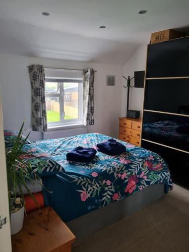 a bedroom with a bed and a window at Family home with garden in Hersham