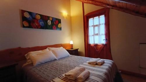 a bedroom with a bed with two towels on it at Aldea Aliwen in Trevelin