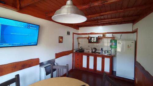 a small kitchen with a table and a tv on the wall at Aldea Aliwen in Trevelin