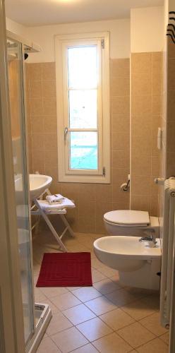 a bathroom with two toilets and a sink and a window at Ostello Dei Concari in Governolo