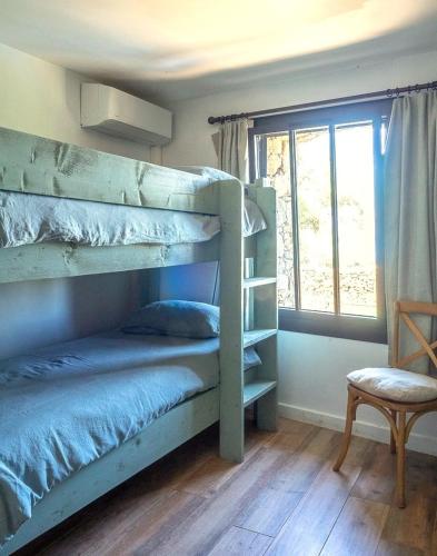 une chambre avec deux lits superposés et une fenêtre dans l'établissement BergerieMuratinca privacy piscine vue mer 16 pers - location du samedi au samedi, à Corbara