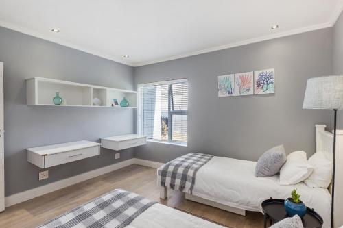 a bedroom with a bed and a window at Melkbos Beachfront Villa in Cape Town