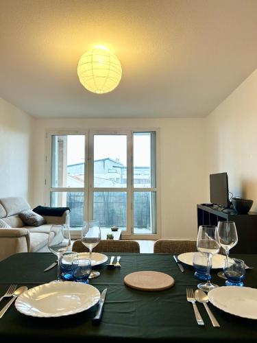 une salle à manger avec une table et des verres à vin dans l'établissement Bois d 'Ormeau - T3 - terrace - quiet - open view, à Toulouse