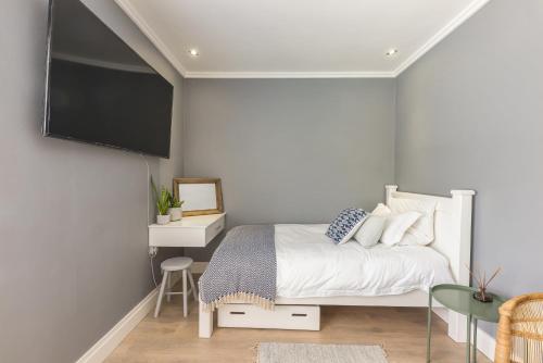 a bedroom with a bed and a flat screen tv at Melkbos Beachfront Villa in Cape Town