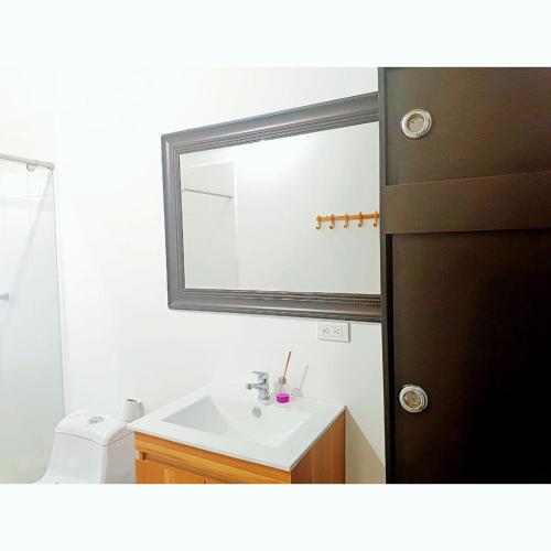 a bathroom with a sink and a mirror at Posada Campestre en Doradal in Puerto Triunfo