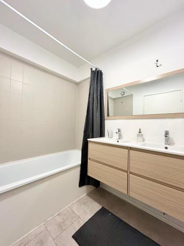 une salle de bain avec une baignoire, un lavabo et un miroir dans l'établissement Bois d 'Ormeau - T3 - terrace - quiet - open view, à Toulouse