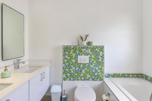 a bathroom with a toilet and a sink and a tub at Melkbos Beachfront Villa in Cape Town