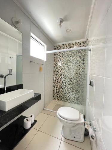 łazienka z toaletą, umywalką i prysznicem w obiekcie Brilho do mar Enseada w mieście Guarujá