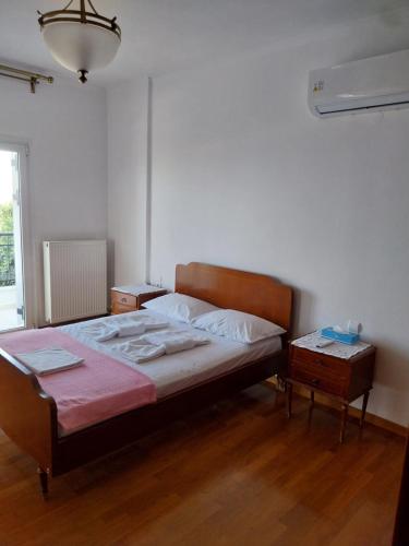 a bedroom with a large bed and a night stand at The Three Graces in Karteros