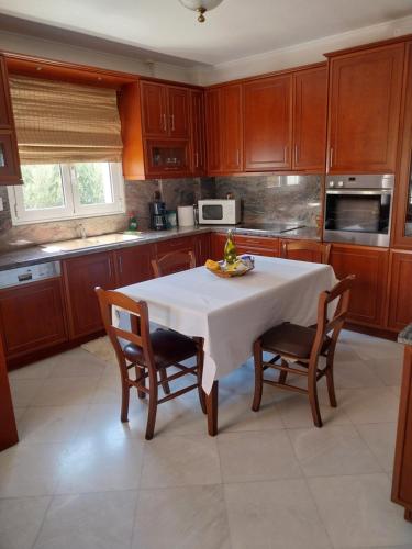 a kitchen with a table with chairs and a microwave at The Three Graces in Karteros