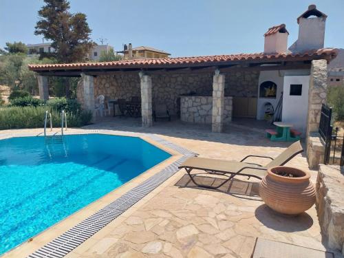 a villa with a swimming pool and a patio at The Three Graces in Karteros