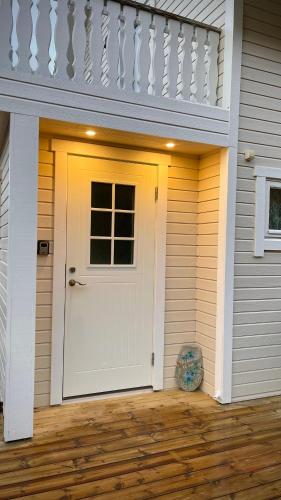 a white door on the side of a house at Sandersstua 2, luxury family apartment with private whirlpool in Stamsund in Vestvågøya