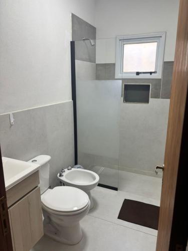 a bathroom with a toilet and a sink and a shower at Cabañas Dos Soles in Córdoba
