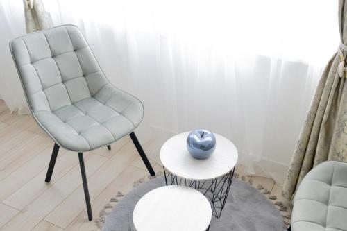 a living room with a chair and a table at Aurora Apartment in Berane