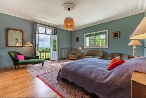 une chambre avec un lit, une chaise et des fenêtres dans l'établissement Manoir de Valmont - Court de tennis, à Hotot-en-Auge